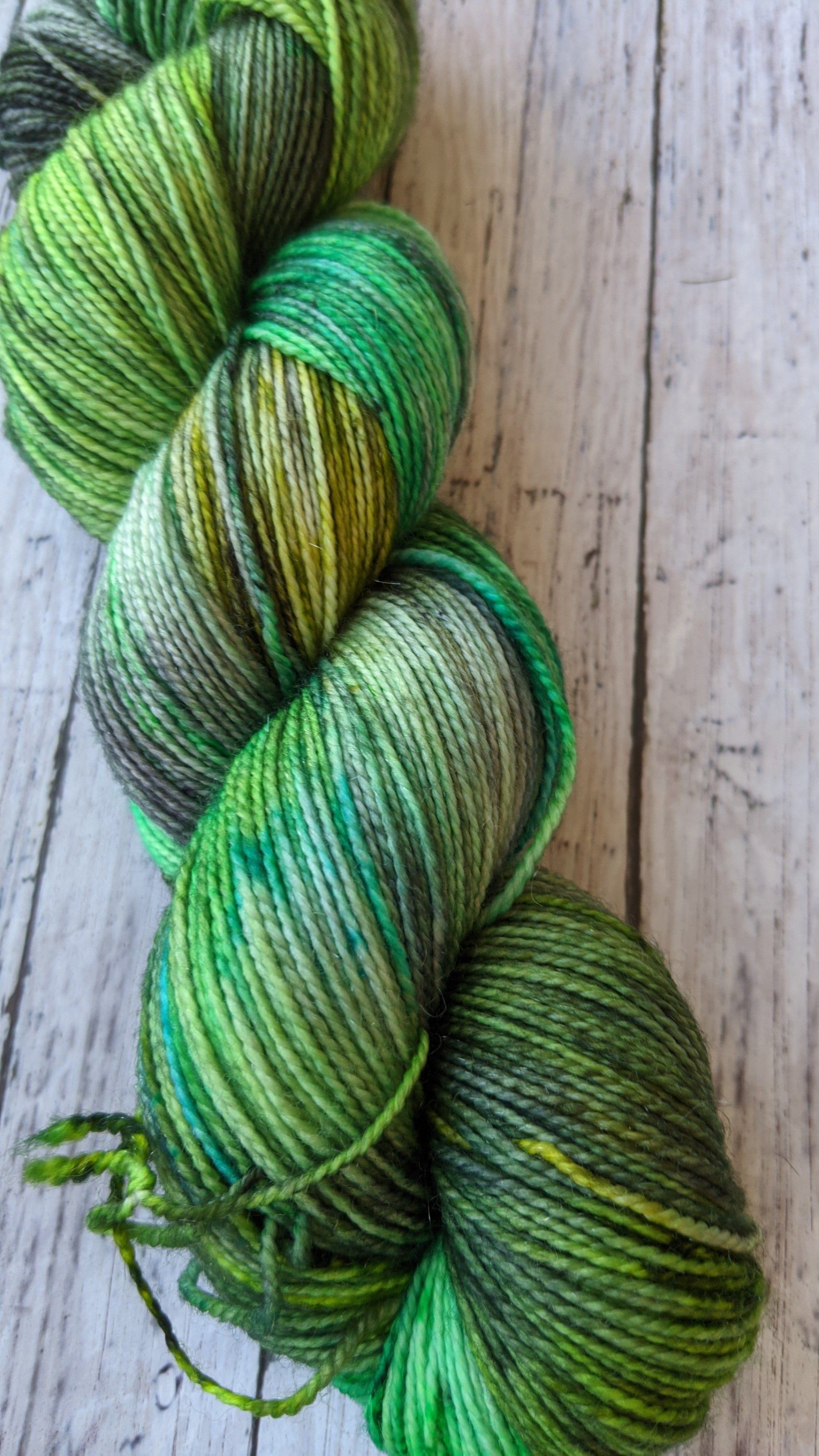 hand dyed various shades of green yarn with black speckles